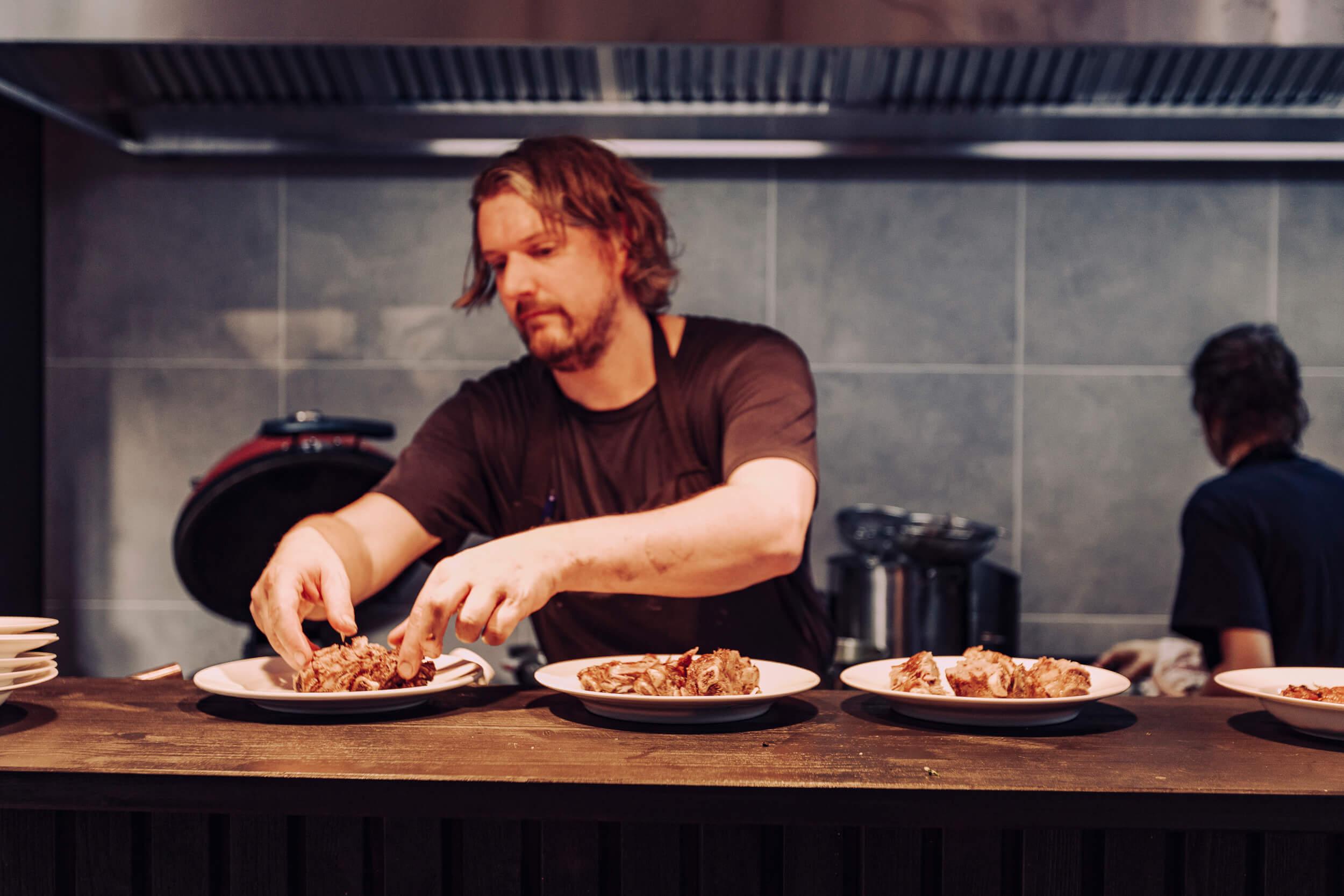 Chef Thijs Steur maakt bord op aan de pas in restaurant de Broeker Huiskamer