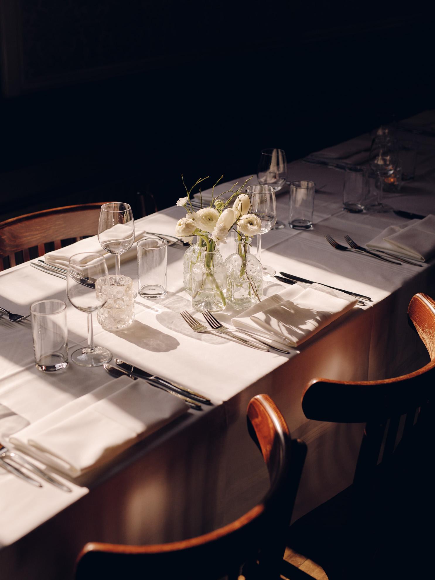 Gedekte dinertafel met bloemen in Grote Zaal van Het Broeker Huis
