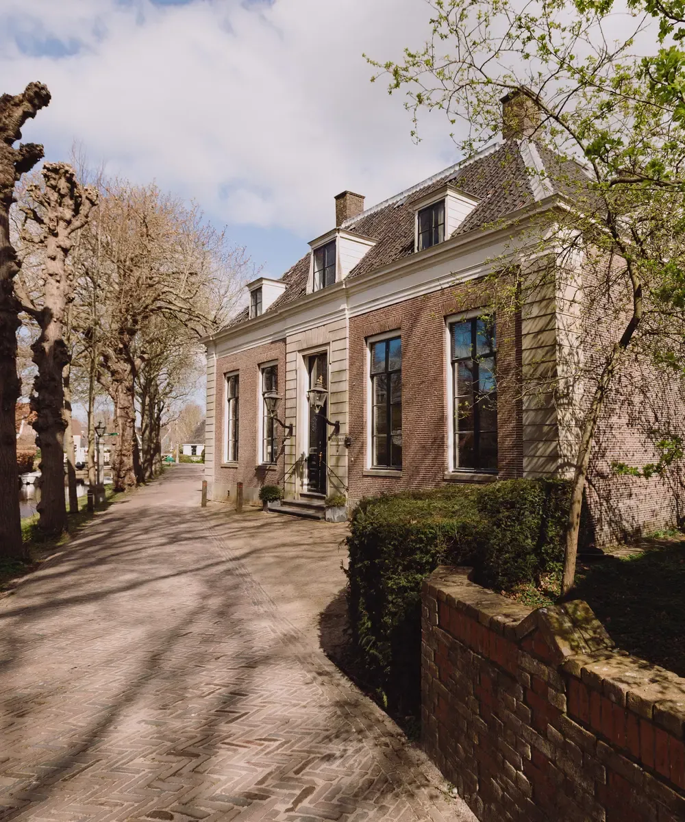 Zijaanzicht Het Broeker Huis met bomenlaan Broek in Waterland