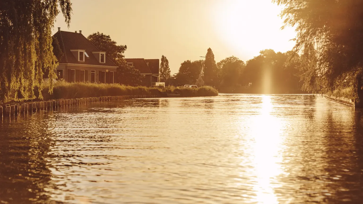 Zonsondergang over gracht in Broek in Waterland