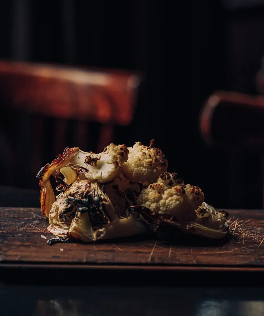Bloemkool van houtvuur op houten snijplank De Broeker Huiskamer