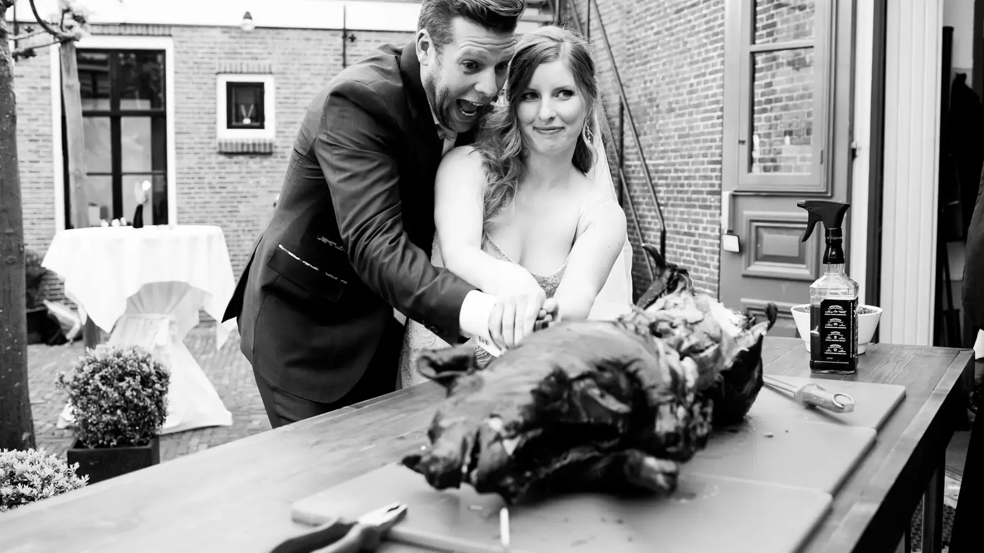 Bruidspaar snijdt speenvarken aan op binnenplaats Het Broeker Huis