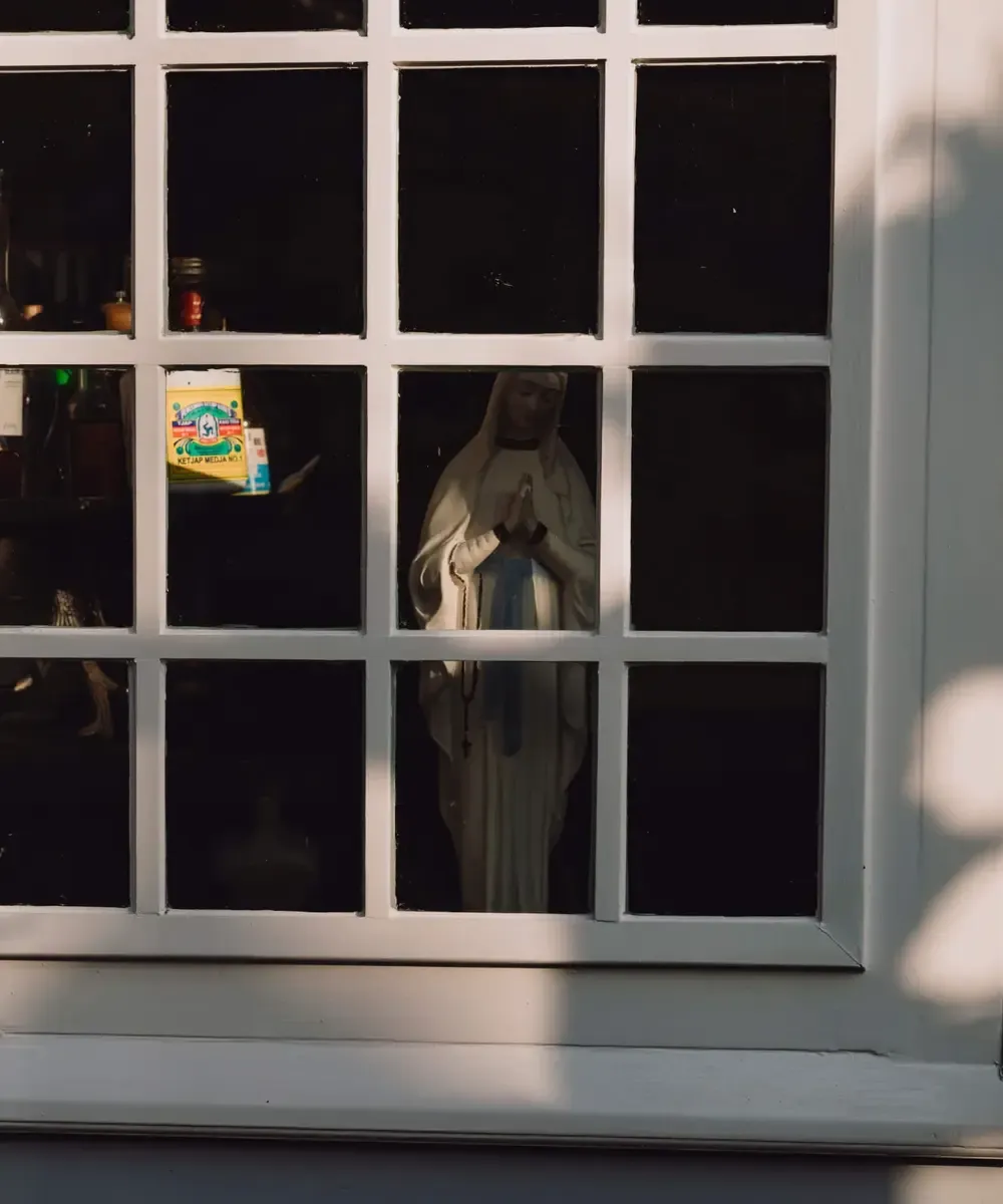 Mariabeeld achter raam houten huis Broek in Waterland