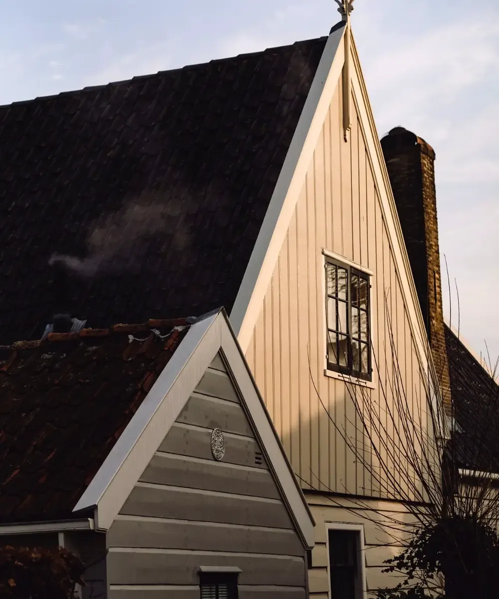 Ochtendlicht op houten huis met windwijzer Broek in Waterland